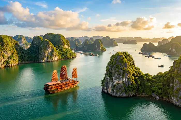 Ha Long Bay Vietnam with traditional junk boat sailing between limestone karsts