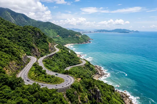 Hai Van Pass coastal road winding along the mountainside above the sea