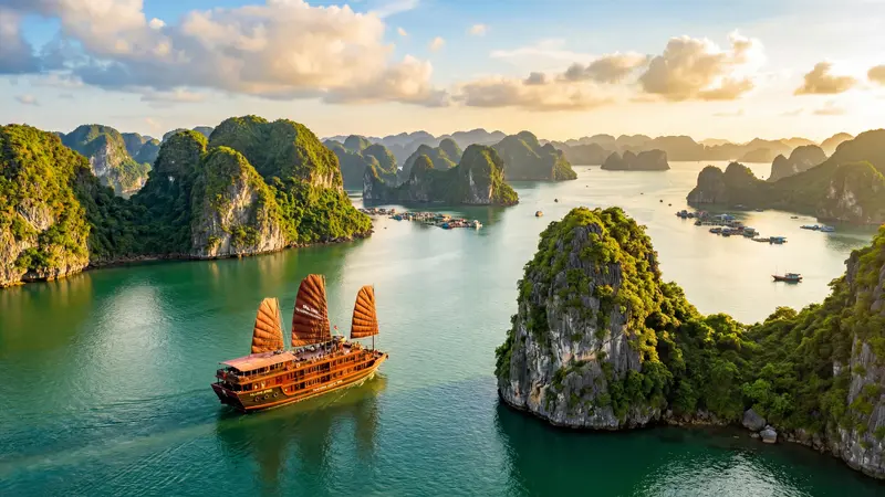 Ha Long Bay Vietnam with traditional junk boat sailing between limestone karsts